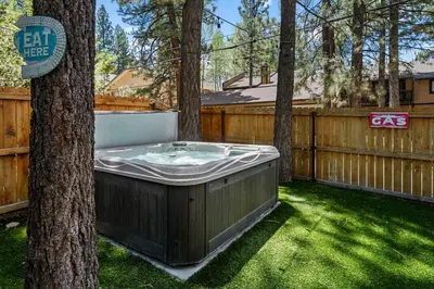 a hot tub in a yard next to a tree at Summit Mountain Lodge - Amazing location just down the street from Snow Summit! in Big Bear Lake