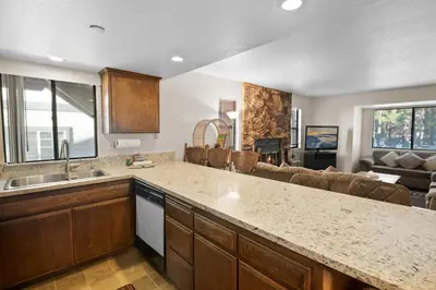 a kitchen with a counter top and a living room at Summit X-ross Roads - Just a short drive to the Village and the lake with forest views! in Big Bear Lake