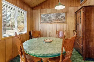 a dining room with a table and chairs at Snowridge - Charming classic cabin with a wood burning fireplace and WiFI! in Big Bear City