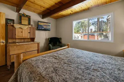 a bedroom with a bed and a window at Bare Necessities - Comes with a hot tub and a pool table in Big Bear Lake