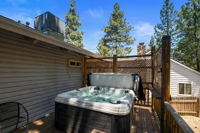a hot tub on the deck of a house at Bare Necessities - Comes with a hot tub and a pool table in Big Bear Lake