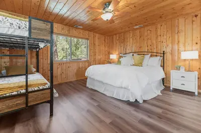 a bedroom with a bed and a ceiling fan at Serenity Knoll - Comfortable, spacious single-level cabin! Newly remodeled! Hot Tub and Pool Table! in Big Bear Lake