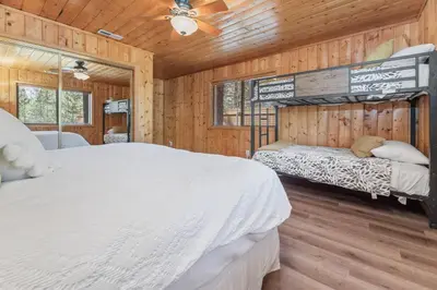 a bedroom with two beds in a wooden cabin at Serenity Knoll - Comfortable, spacious single-level cabin! Newly remodeled! Hot Tub and Pool Table! in Big Bear Lake