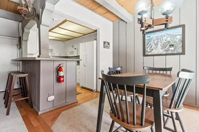 a kitchen and dining room with a table and chairs at Ski-In Ski-Out Summit Townhouse- Perfect mountain getaway with views of the forest and Snow Summit! in Big Bear Lake