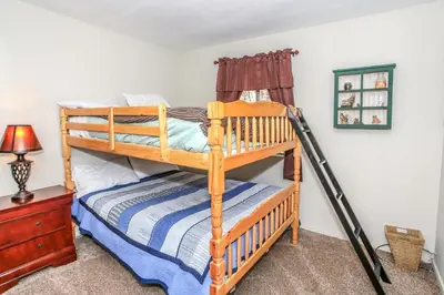 a bedroom with two bunk beds and a lamp at Rincon Cabin - Close to the lake with a huge fenced in yard! Hot tub and deck with barbecue! in Big Bear Lake