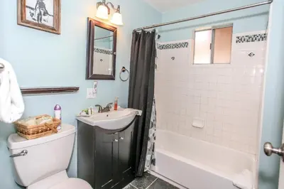a bathroom with a sink and a toilet and a shower at Rincon Cabin - Close to the lake with a huge fenced in yard! Hot tub and deck with barbecue! in Big Bear Lake