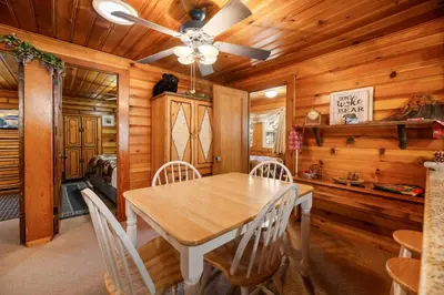 a dining room with a wooden table and chairs at Pine Forest Cabin - Adorable vintage cabin with a cozy wood burning fireplace and foosball table! in Big Bear Lake