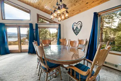 a dining room with a glass table and chairs at North Shore Lakefront - Spacious Lakefront with Hot Tub, & Game Room in Fawnskin