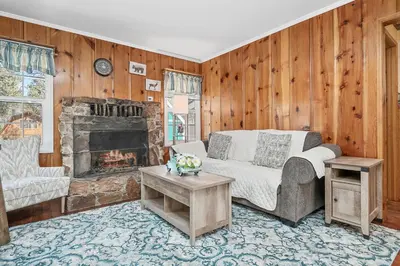 a living room with a couch and a fireplace at Oak Nesting - Great chalet style cabin at the end of the street with rustic stone gas log fireplace! in Big Bear Lake