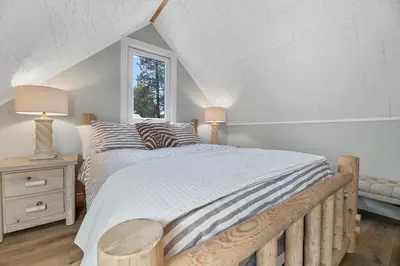 a bedroom with a large bed and a window at Boulder Bay Bungalow - Updated mountain retreat with hot tub, game table, and sauna! in Big Bear Lake