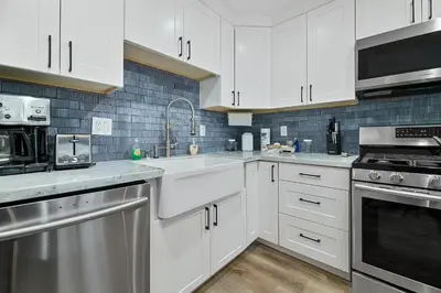 a kitchen with white cabinets and stainless steel appliances at Boulder Bay Bungalow - Updated mountain retreat with hot tub, game table, and sauna! in Big Bear Lake