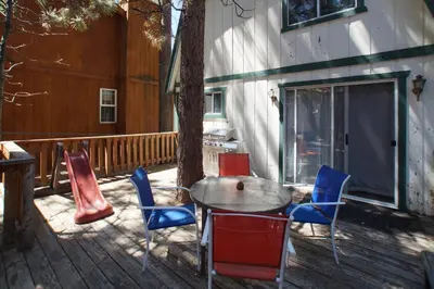 a patio with a table and chairs on a deck at Bear 'n Tree - Cozy cabin near the Village in Big Bear Lake