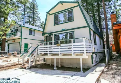 a house with a large balcony on the front of it at Bear 'n Tree - Cozy cabin near the Village in Big Bear Lake