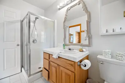 a white bathroom with a sink and a shower at Bear Bait - Lots of games, televisions, beds, telescope, and 3 bathrooms in Big Bear Lake
