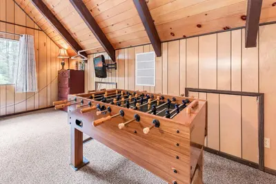 a large wooden foosball table in a room at Bear Crossing - Walk to Snow Summit! Visit this charming mountain home compete with foosball table in Big Bear Lake