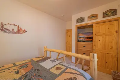 a bedroom with a bed and a dresser and a television at Bearfoot Bungalow - Premium and spacious home close to the National Forest and The Village! in Big Bear Lake