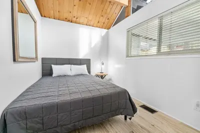 a bedroom with a bed in a white room at Big Bear Lake View - By far the best location Big Bear, walk to Lake! in Big Bear Lake