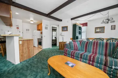a living room with a couch and a table at Boulder Bay Chalet Condo - Mountain charm condo with lake view and WIFI! in Big Bear Lake