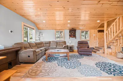 a living room with a couch and a table at Boulder Bear - Modern mountain home in a desirable area of Big Bear with peek-a-boo lake views in Big Bear Lake