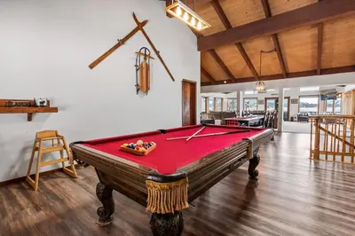 a pool table in the middle of a room at Grand Lakefront Escape - Gorgeous Lakefront home with Hot Tub and Game Room! in Big Bear Lake