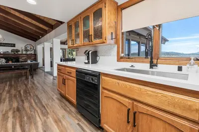 a kitchen with wooden cabinets and a sink at Grand Lakefront Escape - Gorgeous Lakefront home with Hot Tub and Game Room! in Big Bear Lake