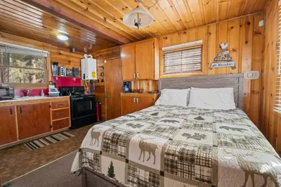 a bedroom with a bed in a wooden cabin at Highland Hideaway - Walk to lake and village! in Big Bear Lake
