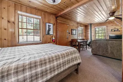 a bedroom with a bed and a table in a room at Highland Hideaway - Walk to lake and village! in Big Bear Lake