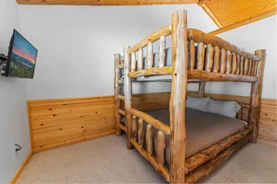 a bedroom with two bunk beds in a house at Kubo Del Sol - DREAM LOCATION WITH HOT TUB! Beautiful, light and bright log cabin! in Big Bear Lake