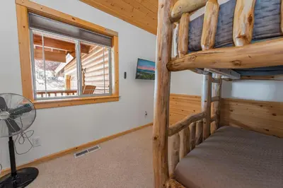 a bunk bed in a room with a fan and a window at Kubo Del Sol - DREAM LOCATION WITH HOT TUB! Beautiful, light and bright log cabin! in Big Bear Lake