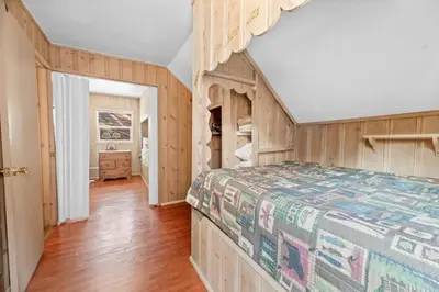 a bedroom with a bed and a wooden floor at Lake Cottage - Vintage Big Bear Cabin close to The Village and Lake in Big Bear Lake