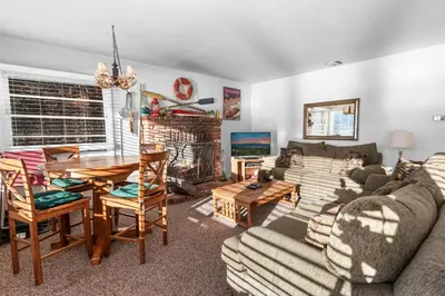 a living room with a couch and a table at Lakefront Retreat - Lakefront cabin near Holloways Marina in Big Bear Lake