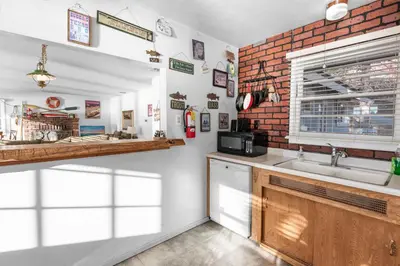 a kitchen with a sink and a brick wall at Lakefront Retreat - Lakefront cabin near Holloways Marina in Big Bear Lake