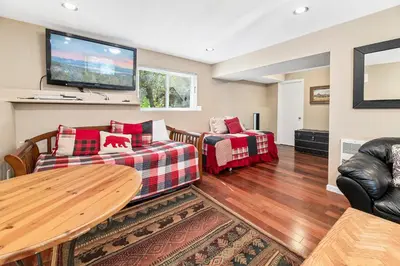 a living room with two couches and a flat screen tv at Lakeview Haven - Large cabin with game room close to the lake! in Big Bear Lake