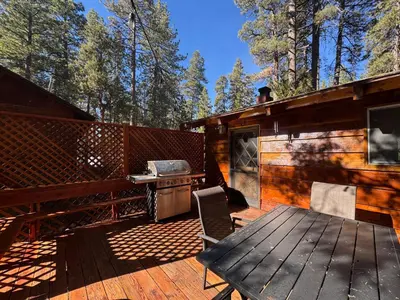a wooden deck with a grill and a picnic table at Little Big Pine - Perfect, stylish cabin near the lake with a great deck in Big Bear Lake