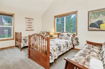 a bedroom with two beds and a crib at Mallard Landing - Steps from the marina and minutes from the Village in Big Bear Lake