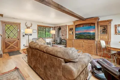 a living room with a couch and a tv at Mallard Landing - Steps from the marina and minutes from the Village in Big Bear Lake