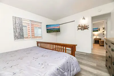 a bedroom with a bed and a television on the wall at Nunu's Cabin - Beautiful cabin, close to ski resorts and town, Hot Tub and Board Games! in Big Bear Lake