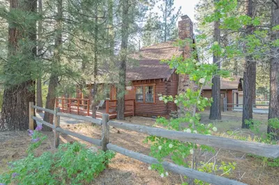 a log cabin in the woods with a fence at Rustic Pine - Rustic true log cabin with plenty of charm, Close to everything! in Big Bear Lake