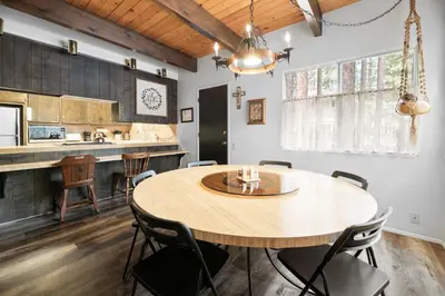 a kitchen and dining room with a wooden table and chairs at Sky Krest - Located on a quiet street in the middle of town, Games! Pool table! in Big Bear Lake