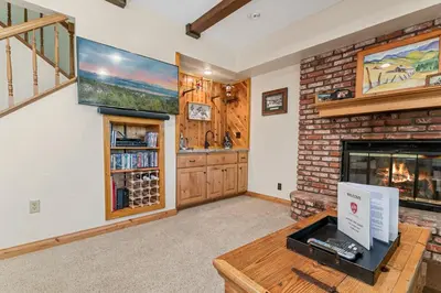 a living room with a fireplace and a brick wall at Whiskey Pines Chalet - Warm and cozy cabin with modern features made more fun with a gameroom in Big Bear Lake