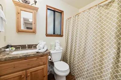 a bathroom with a toilet and a sink and a shower at Whiskey Pines Chalet - Warm and cozy cabin with modern features made more fun with a gameroom in Big Bear Lake