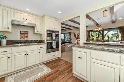 a kitchen with white cabinets and a counter top at Whiskey Pines Chalet - Warm and cozy cabin with modern features made more fun with a gameroom in Big Bear Lake