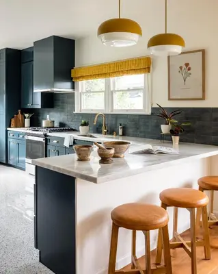 a kitchen with black cabinets and a counter with stools at The Richland in Orange