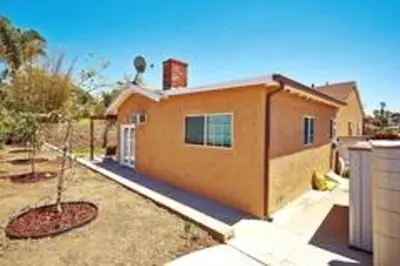 a house with a tree in front of it at Stylish 4 Bedroom Home Near Venice Beach with Backyard BBQ in Los Angeles
