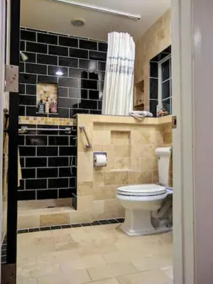 a bathroom with a toilet and a shower with black tiles at Stylish 4 Bedroom Home Near Venice Beach with Backyard BBQ in Los Angeles