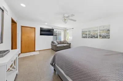 a bedroom with a bed and a couch and a ceiling fan at Spacious pool home in Pasadena in Pasadena