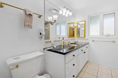a white bathroom with a sink and a toilet at Spacious pool home in Pasadena in Pasadena