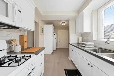 a white kitchen with a stove and a sink at Spacious Centrally Located NEW 2 Bedroom Property! in Inglewood