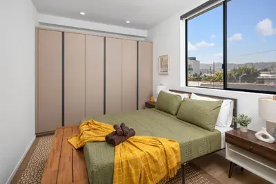 a bedroom with a bed and a large window at Modern Hollywood Charm in Los Angeles