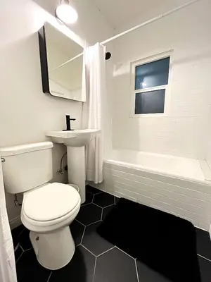a bathroom with a toilet and a sink and a tub at Heart of Hollywood Apartment - 2Bed 2Bath in Los Angeles